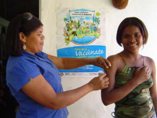 Promotora de salud vacuna una mujer embarazada.