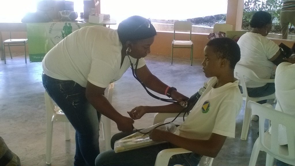 Health Promoters practicing how to take blood pressure and check sugar levels.